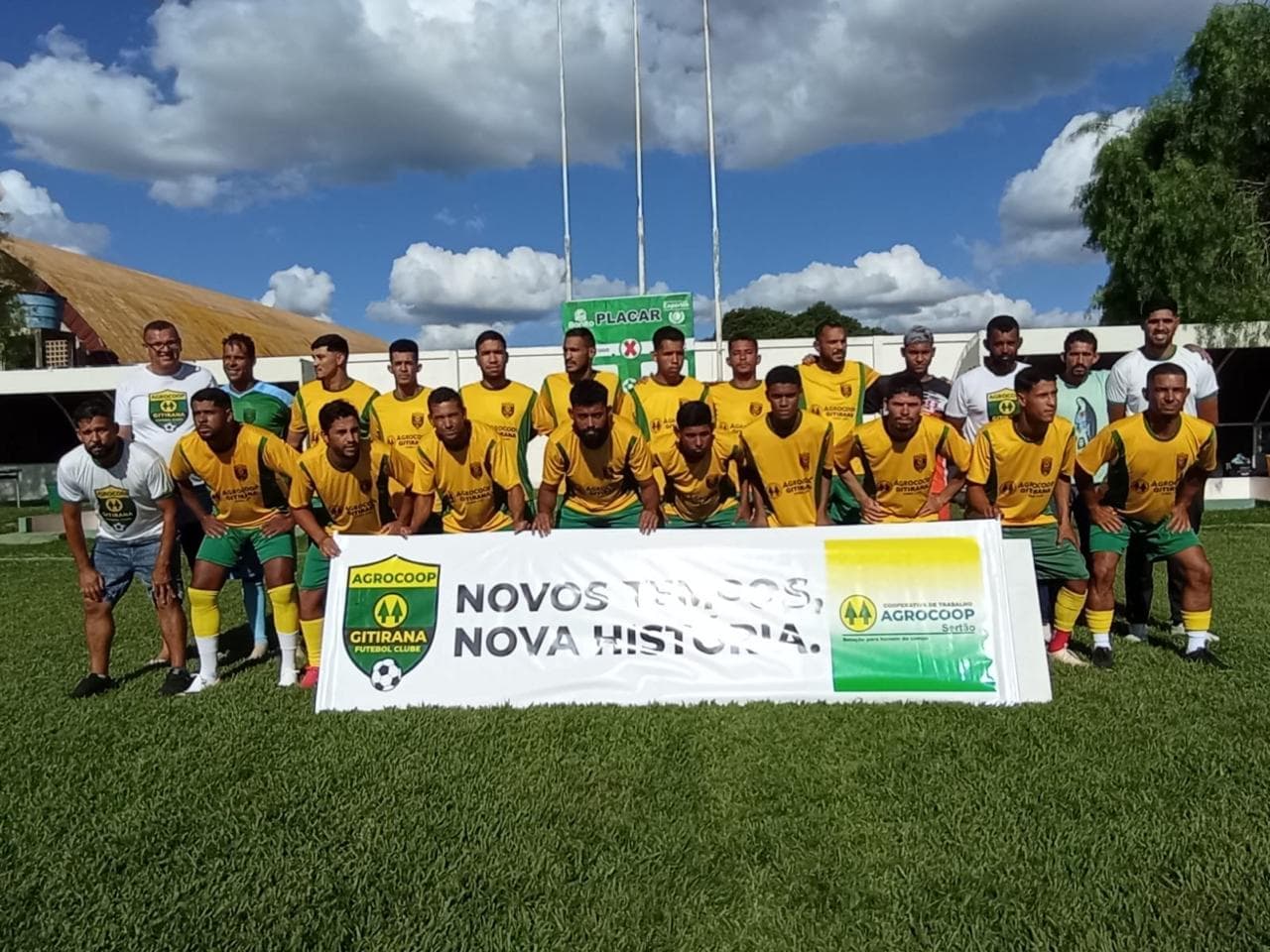 Equipe AGROCOOP Gitirana perfilada em campo com a faixa “Novos tempos, nova história”